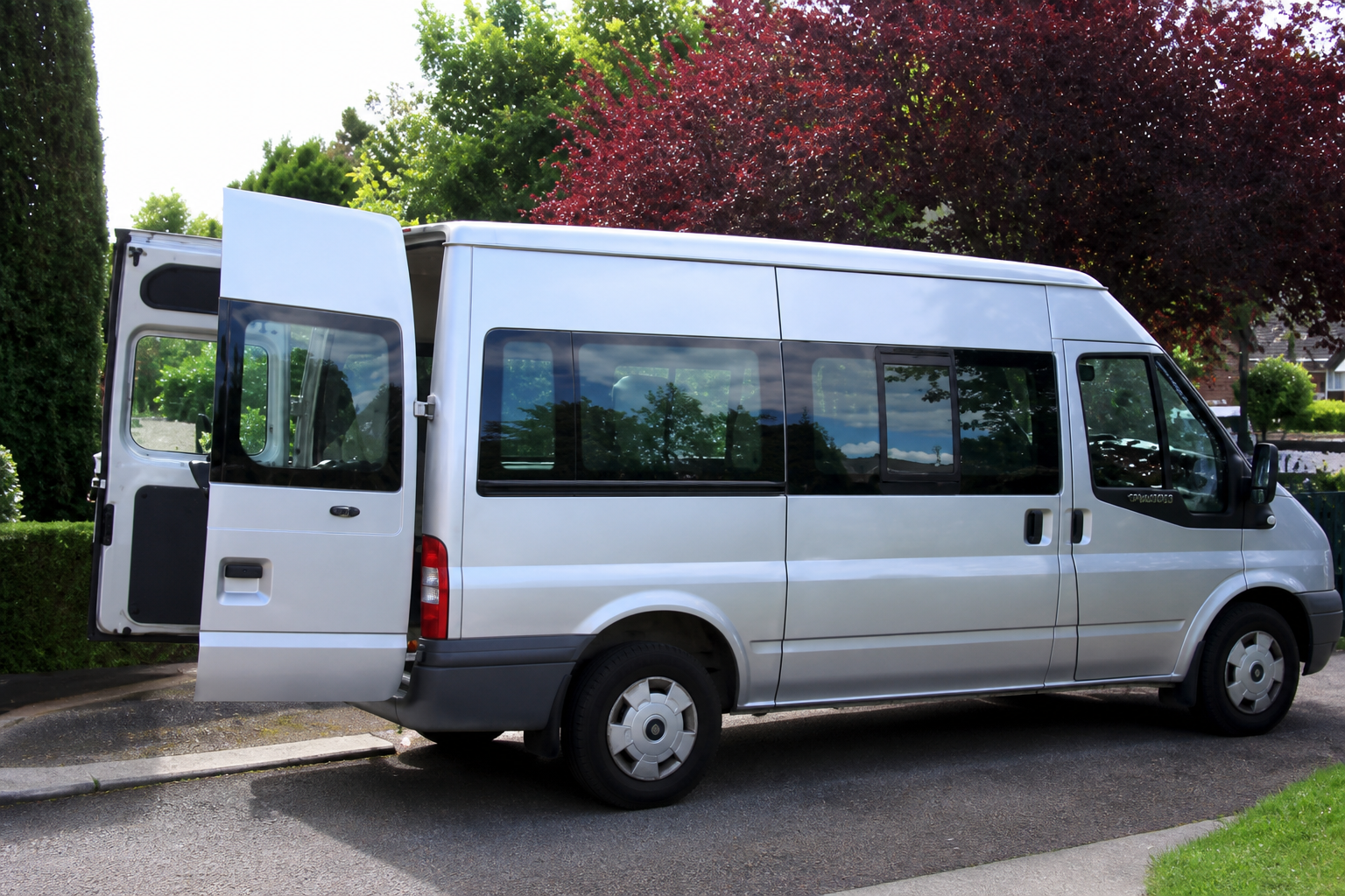 Accessible silver passenger vehicle with rear access door open